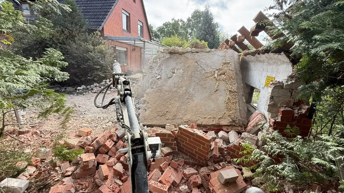 Baggerarm zieht Mauerwerk und Betondecke herunter